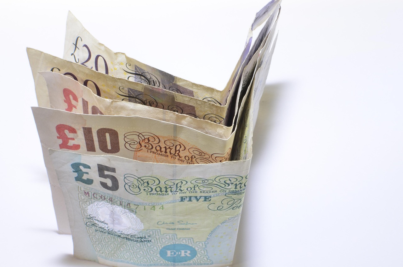 Due mani che dividono una banconota su un tavolo, simbolo di un conto cointestato in fase di separazione.